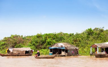Chong Kneas, Kamboçya-6 Ağustos 2009: Siem Reap yakınlarındaki bir yüzen ev köyünde, bir adam mallarını satmak için taşır.