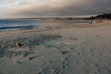 Monterey, ABD-12 Haziran 2017: Monterey, Kaliforniya sahillerinde gün batımı. Erkekler geziden sonra kanoyu alır.