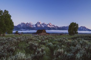 John Moulton Barn, Grand Teton Ulusal Parkı 'nda, Mormon Row bölgesinde güneş doğarken.