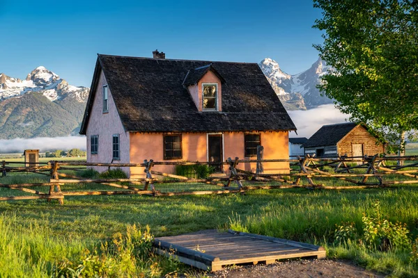 Antilop Düzlükleri 'ndeki tarihi Morman Row çiftliğinin bir parçası olan taşra binası Grand Teton Ulusal Parkı Wyoming' de gün doğumunda