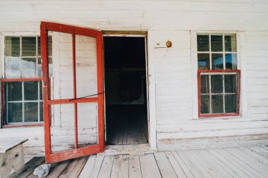 Bannack Hayalet Kasabası Montana 'da terk edilmiş bir binada eski ahşap bir kırmızı kapı açıldı.