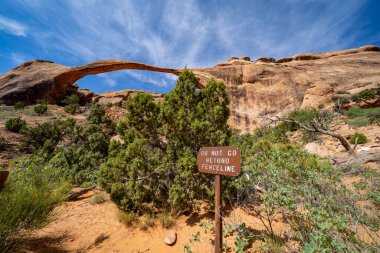 Utah Arches Ulusal Parkı 'ndaki Devils Garden yolunda peyzaj kemeri. Yürüyüşçüleri çitin ötesine geçmemeleri için uyaran bir işaret.