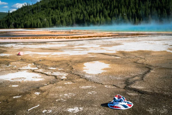 A bucket hat was dropped and littered by a tourist in the Grand Prismatic Spring in Yellowstone National Park, focus on the hat