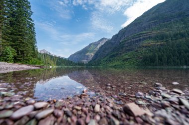 Buzul Ulusal Parkı 'nda alçak açılı Avalanche Gölü' nde ön planda kayalar var.