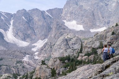 Colorado, ABD - 1 Ağustos 2021: Yürüyüşçüler Rocky Dağı Ulusal Parkı 'ndaki Gölet Yolu boyunca manzaranın tadını çıkarıyorlar