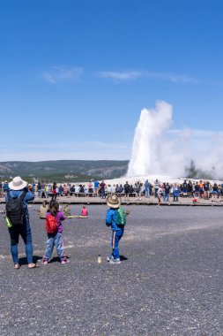 Wyoming, ABD - 10 Ağustos 2021: Yellowstone Ulusal Parkı 'nda Old Faithful' un patlaması için tahta kaldırımlar boyunca turist kalabalığı bekliyor