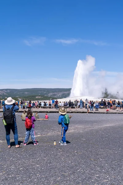 Wyoming, ABD - 10 Ağustos 2021: Yellowstone Ulusal Parkı 'nda Old Faithful' un patlaması için tahta kaldırımlar boyunca turist kalabalığı bekliyor