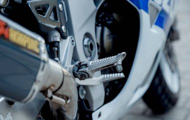 Caddelere park etmiş motosiklet. Ayak motorun ön tarafında dinleniyor..