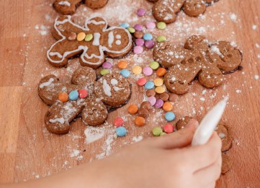 Noel kurabiyesi kesen çocuk. Noel için zencefilli kurabiye yapıyorum. Noel süslemeli masada, ışıklandırma arka planında zencefilli kurabiye yapmak.