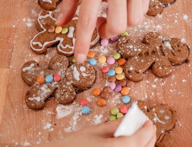 Noel kurabiyesi kesen çocuk. Noel için zencefilli kurabiye yapıyorum. Noel süslemeli masada, ışıklandırma arka planında zencefilli kurabiye yapmak.