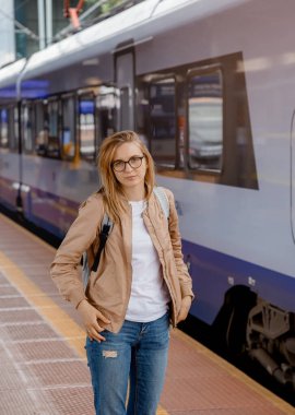 Platformda treni bekleyen genç bir kadın. Tren istasyonundaki güzel kız. Trenle seyahat et. Bydgoszcz 'deki tren istasyonu. Polonya.