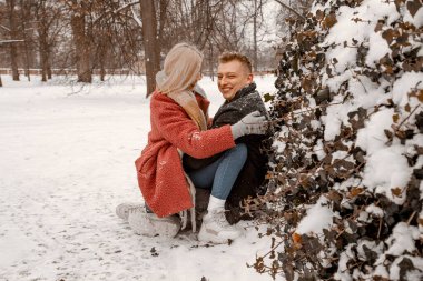 Sokakta poz veren genç ve mutlu bir çiftin belden yukarı portresi. Anlaşıldı, boş uzay. Kışlık kıyafetlerle buluşup doğal ortamdaki kameralara bakmak. Kar yağıyor. Kış Tatili.