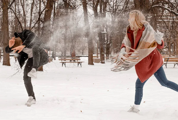 Outdoor waist up portrait of young beautiful happy smiling couple posing on street. Copy, empty space. Embracing dates in winterwear looking at camera in natural environment. Snow. Winter Vacation. Stock Picture