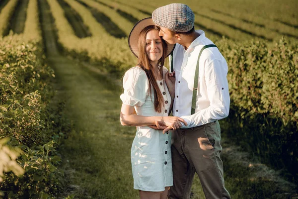 Amar a la joven pareja abrazándose juntos en la naturaleza en el fondo del campo. Foto de alta calidad. Pareja inusual de pareja joven con estilo tienen su matrimonio en el campo. La mujer es feliz y sonriente. — Foto de Stock