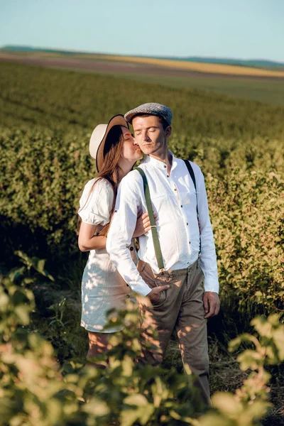 Amar a la joven pareja abrazándose juntos en la naturaleza en el fondo del campo. Foto de alta calidad. Pareja inusual de pareja joven con estilo tienen su matrimonio en el campo. La mujer es feliz y sonriente. — Foto de Stock