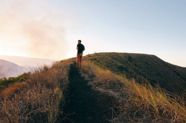 Gün batımında patikada yürüyen bir adam Orta Amerika, Nikaragua 'da volkan ulusal parkında
