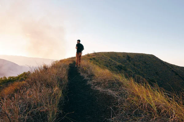 Gün batımında patikada yürüyen bir adam Orta Amerika, Nikaragua 'da volkan ulusal parkında