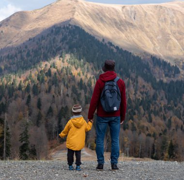 Genç baba ve oğul dağlarda yürüyorlar. Dağlarda dolaş. Güzel manzara..