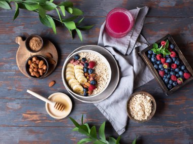 Wholesome breakfast. There are plates of food on the wooden table. Oatmeal porridge with berries.