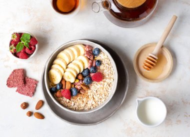 Sağlıklı beslenme. Yulaf ezmesi. Yulaf lapası malzemeleri. Sağlıklı bir kahvaltı. Lezzetli yaz meyveleri. Faydalı fındık.