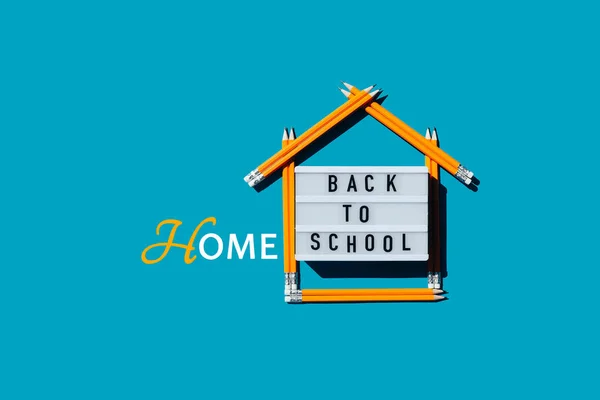Lightbox s nápisem zpět do domácí školy a domem z tužek. Royalty Free Stock Fotografie