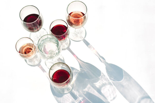 Wine of different varieties in glasses on a white background.