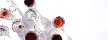 Beyaz arka planda farklı türde bardaklarda şarap. Gözlükten yapılmış şık sert gölgeler.