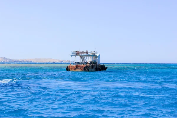 Vecchia chiatta arrugginita galleggiante sul mare — Foto Stock
