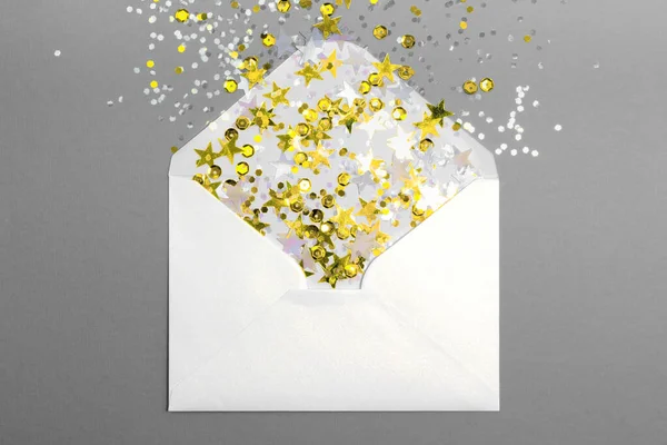 Espumante confete espalhado do envelope no fundo cinza. — Fotografia de Stock