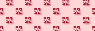 Pembe arka planda pembe kurdeleli kırmızı hediye kutularının deseni.