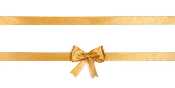 Fita de cetim dourado com um arco isolado no fundo branco. — Fotografia de Stock