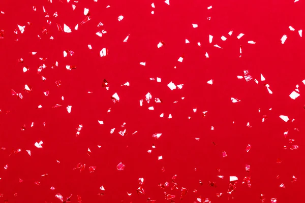 Confeti metálico sobre fondo rojo. —  Fotos de Stock