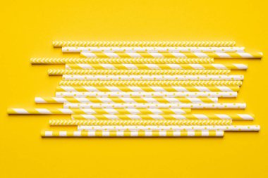 Parlak sarı arkaplanda sarı kağıt pipetler.