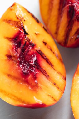 Açık gri kesme tahtasında sulu ızgara nektarin çeyreklikleri.