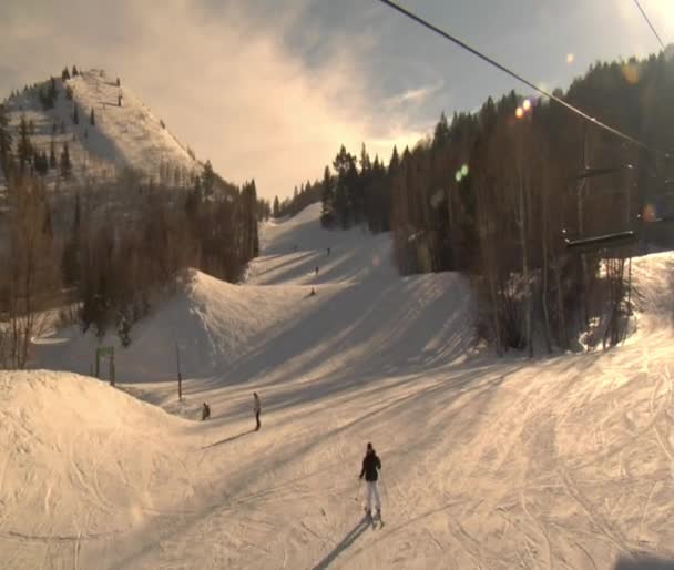 Chairlift, looking down at skiiers on hill — Stock Video