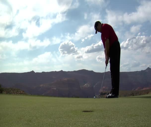 Homem putts bola de golfe — Vídeo de Stock