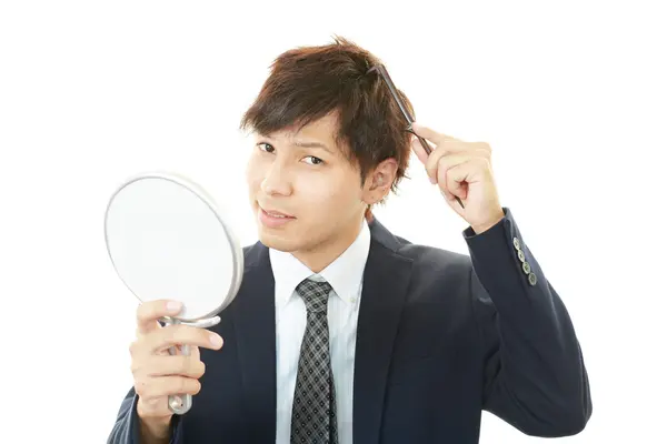 Homem cuidando de seu cabelo — Fotografia de Stock