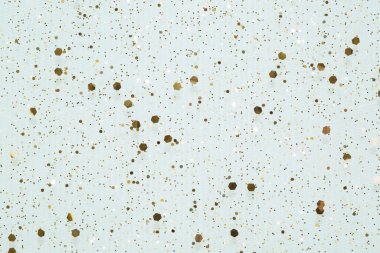 Açık mavi düz zeminde altın yaldızlı konfeti ile tatil arkaplanı ışıldıyor. Şenlikli soyut arkaplan.