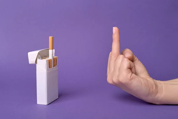 The middle finger, hand gesture to a cigarette treat from a pack, refusing cigarette.