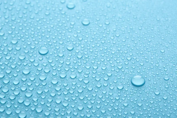 Gotas de agua pura sobre fondo abstracto azul o textura. — Foto de Stock