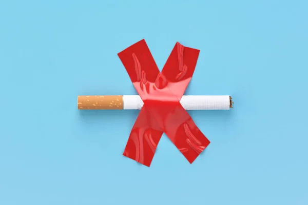 Crossed out cigarette, glued with red adhesive tape, no smoking concept. Stock Image