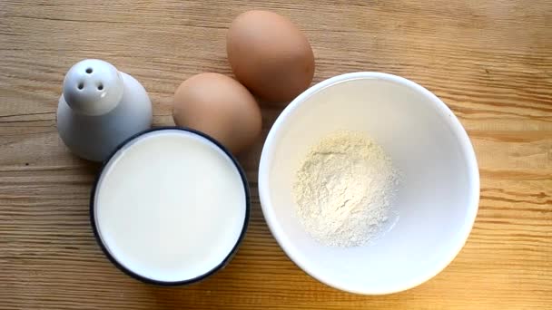 Farinha de Nasypany e leite em uma tigela. Ingredientes leite, sal, ovos, farinha — Vídeo de Stock