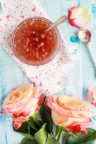 Small jam dish with rose petal jam on a blue wooden table with f