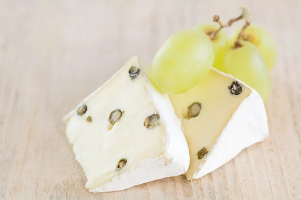 Twee stukken van Brie met groene peper — Stockfoto