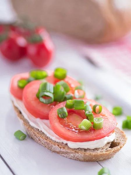 Una fetta di pane ricoperta di pomodori — Foto Stock