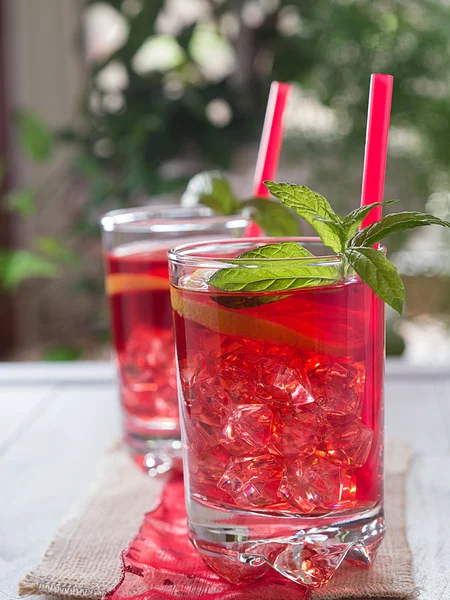 Cocktail com fatias de limão e cubos de gelo em um copo — Fotografia de Stock