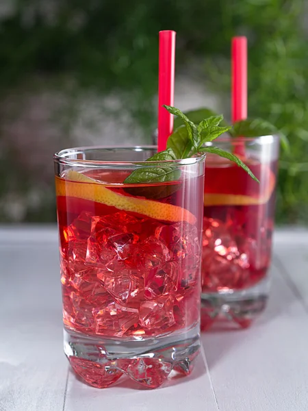 Cocktail com fatias de limão e cubos de gelo em um copo — Fotografia de Stock