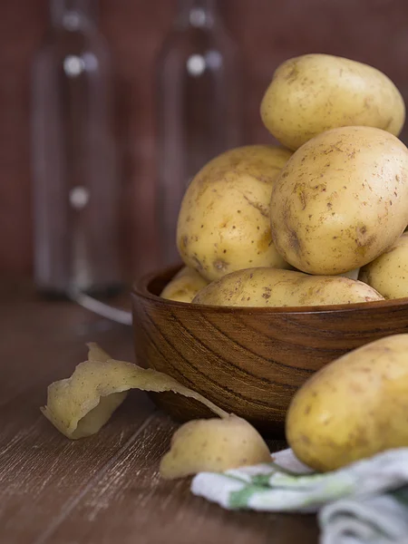 Raw potatoes in a wood bowl — Stock Photo, Image