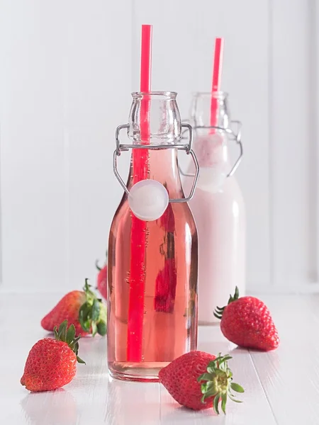 Strawberry juice and strawberry milk in bottles — Stock Photo, Image