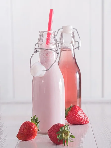 Strawberry juice and strawberry milk in bottles — Stock Photo, Image